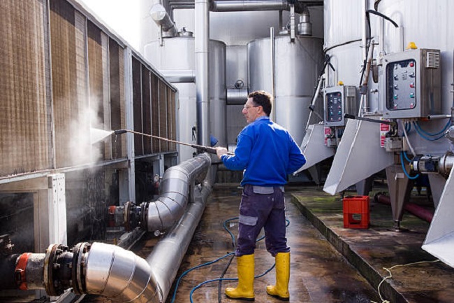worker cleaning with a washer in a site